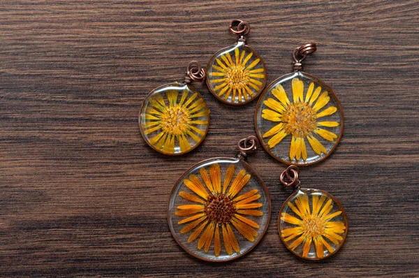handmade epoxy resin jewelry. pendant. calendula officinalis flower in copper frame. dried flowers. herbarium, oshibana, phytotherapy.