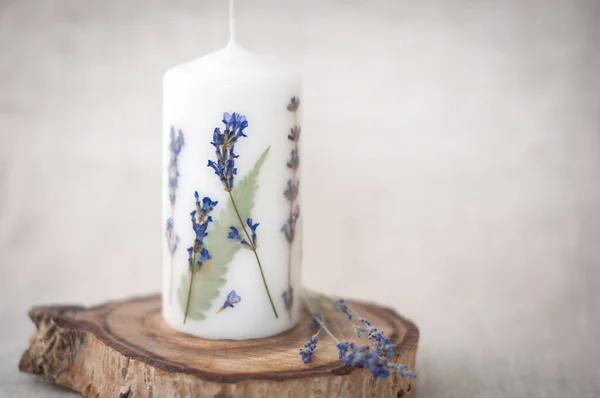 Candle with herbarium flowers. dried flowers. on linen background