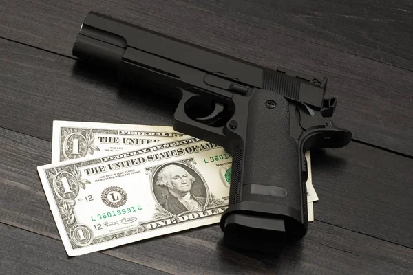 Banknotların üzerinde siyah silah. Silahlı suç kavramı