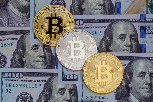 Different metal bitcoins on hundred dollar background — Stock Photo, Image