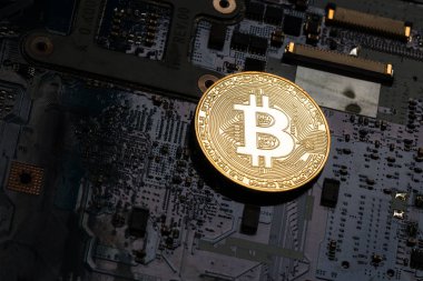 Parlak altın bitcoin karanlık bir anakart üzerinde. Çekim sanat