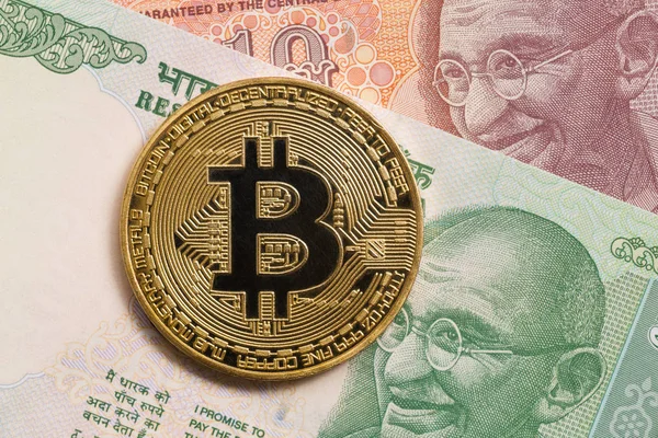 Gyllene bitcoin och indiska rupier pengar. Stockbild