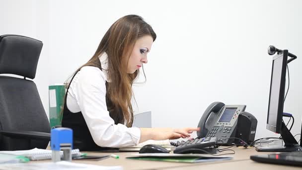 Chica joven en el lugar de trabajo en la oficina o en el banco — Vídeos de Stock