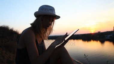 gün batımı sırasında Riverside'da bir defter ile yaratıcı Kişilik