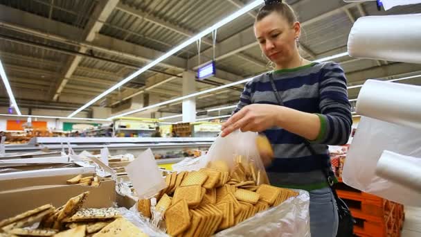 Menina um cliente escolhe uma sobremesa no balcão do supermercado — Vídeo de Stock
