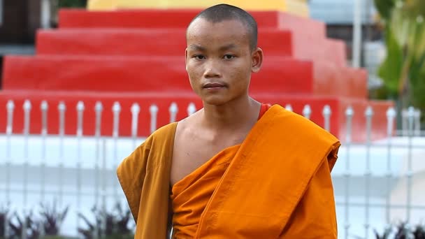 LUANG PRABANG, LAOS - 9 de diciembre de 2016: Video retrato de un joven monje budista. Los monjes son educados en escuelas budistas en los templos de la ciudad. — Vídeos de Stock