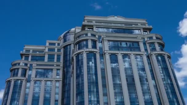 Time lapse white clouds reflected in the windows of a large office building — Stock Video