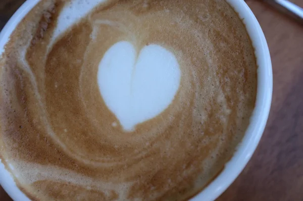 Tasse à café blanc chaud avec latte art en forme de coeur — Photo