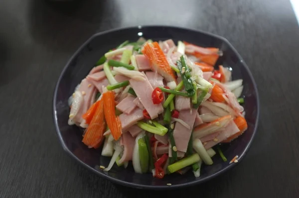 Ensalada caliente y picante con jamón y palillo de cangrejo de imitación —  Fotos de Stock