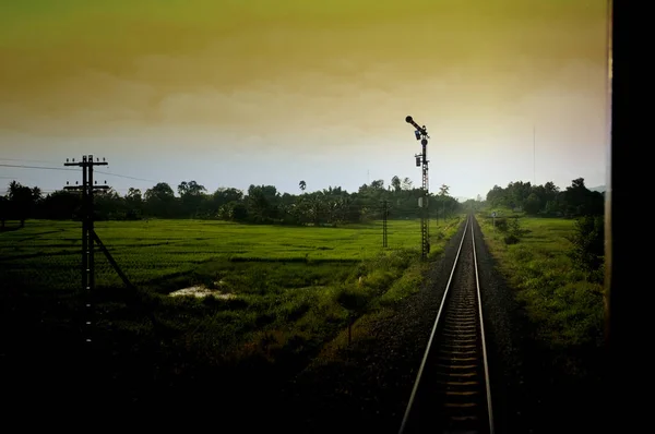 Κάτοψη των σκουριασμένων σιδηροτροχιών που διασχίζουν το πράσινο πεδίο σε μια καλοκαιρινή ημέρα, Βόρεια Σιδηροδρόμων Ταϊλάνδης — Φωτογραφία Αρχείου