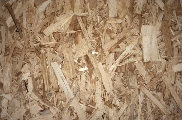 OSB Boards or brown wood chips sanded into a wooden background. — ストック写真