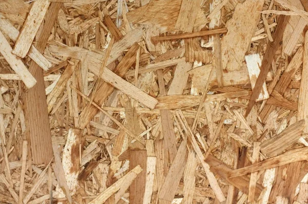 Tableros OSB o astillas de madera marrón lijadas en un fondo de madera . —  Fotos de Stock