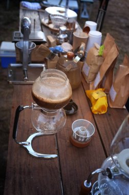 Close up of hot coffee brewing gadgets on wooden table counter. clipart