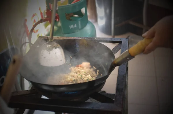 La femme cuisinant du riz frit thaïlandais aux crevettes — Photo