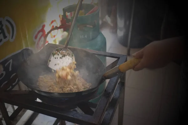 A mulher que cozinha o arroz frito tailandês com camarões — Fotografia de Stock