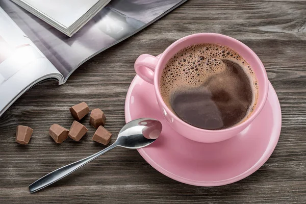 Koffie, chocolade en een tijdschrift op tafel. — Stockfoto