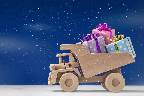 Lieferung von Geschenken auf Spielzeugwagen. Geschenkkonzept für den Urlaub. — Stockfoto