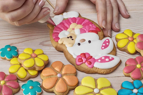 Pastelero decora galletas en forma de conejo . —  Fotos de Stock