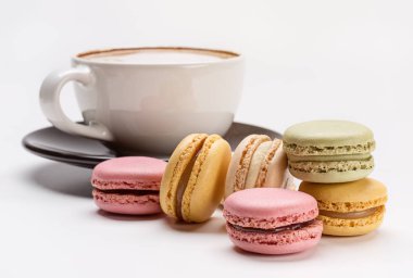Baştan çıkarıcı renkli macaroons ve sıcak cappuccino. Fransızca macaroons ile kahve molası.