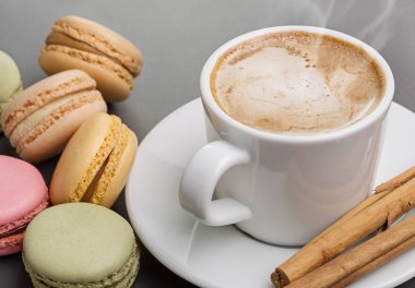Beyaz bardak, kaşık uçan daire ve renkli taze kapuçino Fransızca macaroons. Kopya alanı.