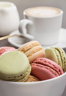 Beyaz bardak, kaşık uçan daire ve renkli taze kapuçino Fransızca macaroons. Kopya alanı.