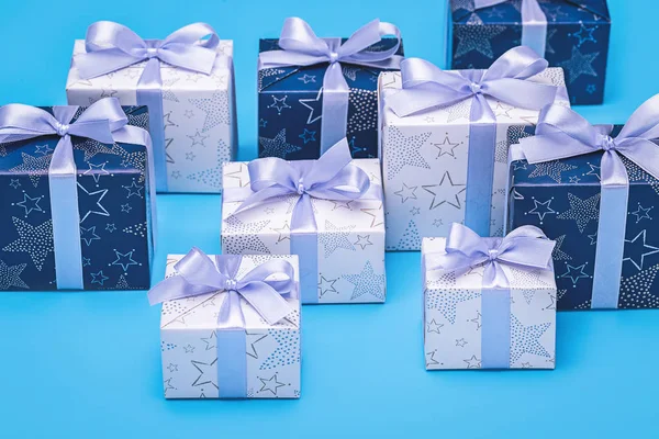 Подарункові Коробки Елегантному Папері Бузковими Стрічками Бантами Синьому Фоні Святами — стокове фото