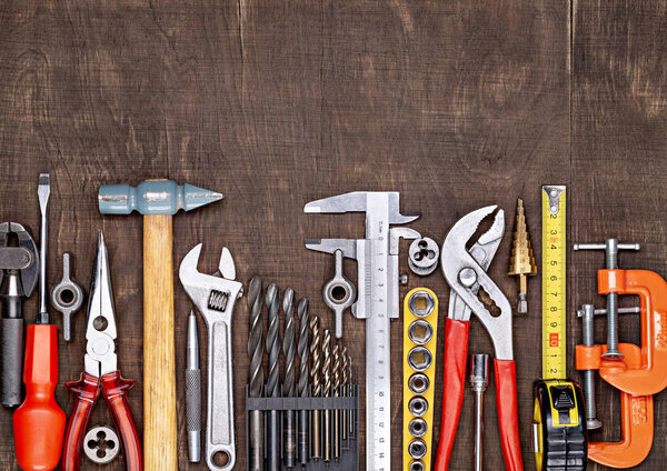 Tools in workshop. On table are tools for various types of construction and repair work on wood, metal, concrete, plastic and other materials