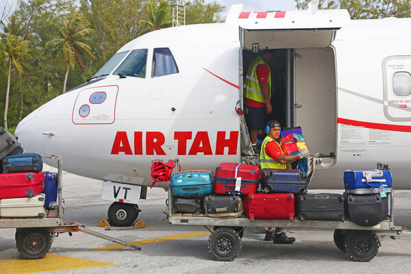 Man unloading baggages from Air Tahiti airplane 