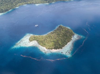 Raja Ampat engebeli kireçtaşı Islands yakınındaki bir gemi yüzer. Doğu Endonezya uzaktaki bir parçası bu güzel bölgede olağanüstü deniz biyoçeşitliliği için bilinen.