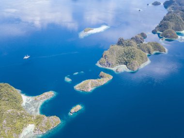 Raja Ampat, Endonezya, estetik kireçtaşı adalar sağlıklı, sığ resifleri ile çevrilidir. Bu bölge Doğu Endonezya deniz biyoçeşitliliği nedeniyle Mercan Üçgeni kalbinde olarak bilinir.