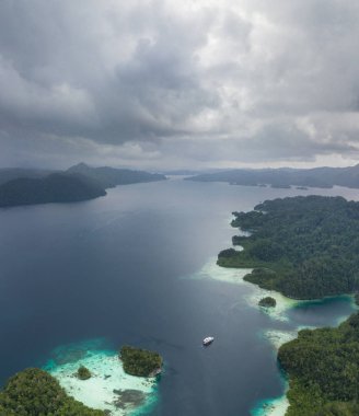 Raja Ampat, Endonezya koyda Alyui üzerinde yağmur bulutları drift. Bu uzak, Ekvator bölgesi deniz biyolojik çeşitlilik olağanüstü bir dizi ev.