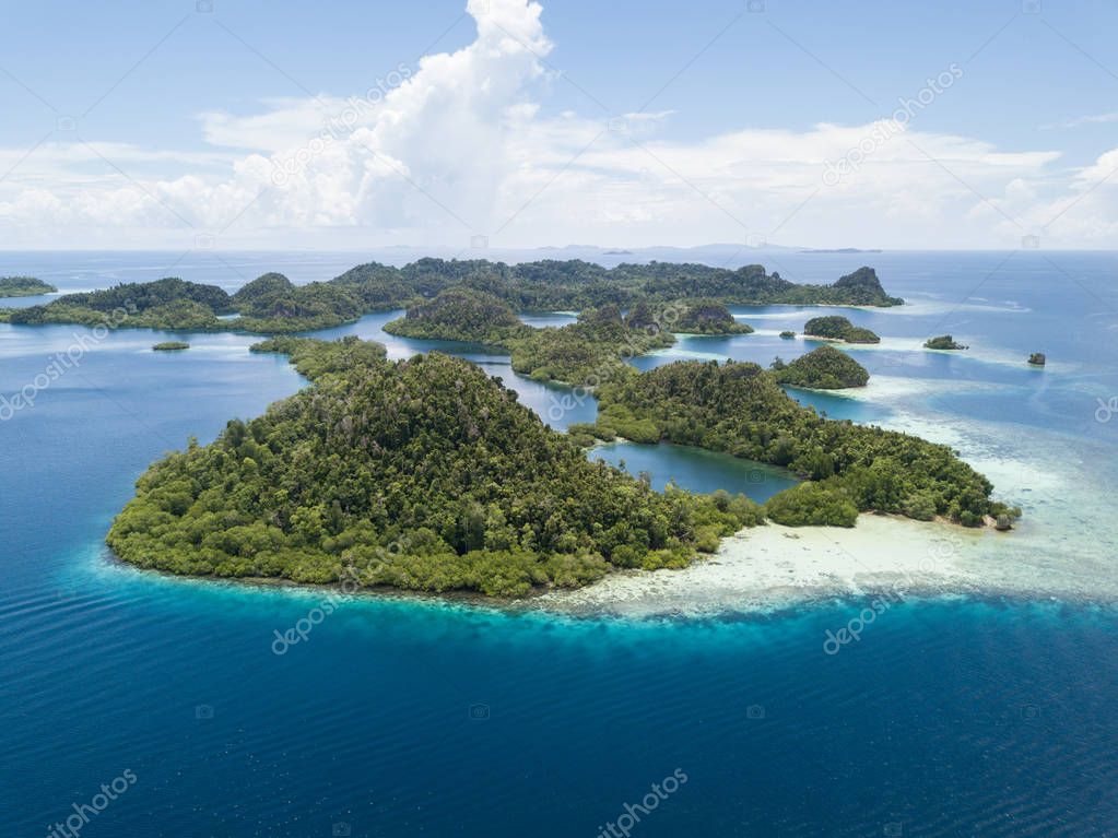 The beautiful tropical islands of Pef are surrounded by calm seas in the equatorial seascape of Raja Ampat, Indonesia. This unique region is best known for its vast array of marine biodiversity.