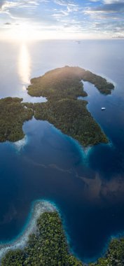 Raja Ampat, Endonezya güzel Adaları kümesi üzerinde güneş batacak. Bu bölge 