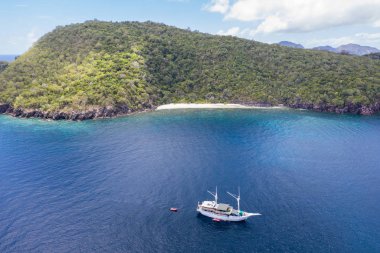 Bir Pinisi yelkenlisi Endonezya 'nın Banda Denizi' ndeki uzak bir adanın yakınında demirliyor. Doğu Endonezya 'nın bu bölümü dünyanın en büyük deniz biyolojik çeşitliliğine ev sahipliği yapmaktadır..