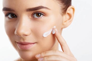 Çekici kız Anti-Aging Krem onun yüzüne koydu. Sağlıklı pürüzsüz bir cilt ile kız portresi