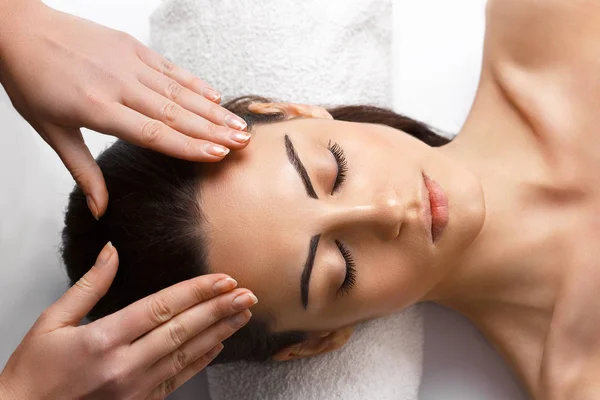 Pretty young girl with thick eyebrows and perfect skin doing facial massage, beauty photo concept, hands on face, skin care, closed eyes, close up. — Stock Photo, Image