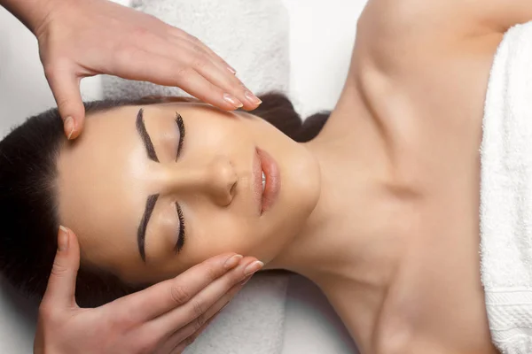 Masajista haciendo masaje la cabeza de la mujer en el salón de spa — Foto de Stock