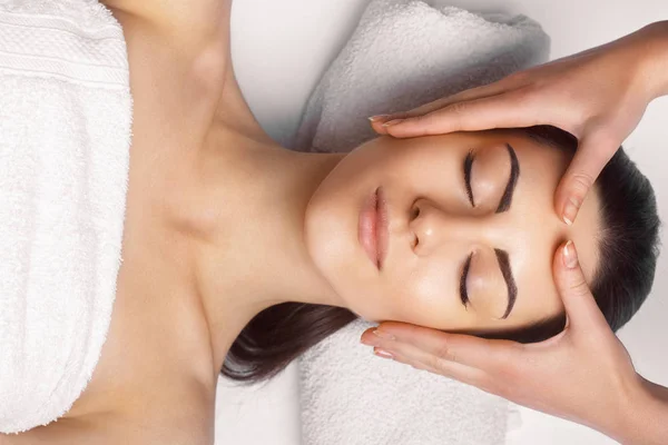 Massagem facial. Close-up da jovem mulher recebendo tratamento de massagem spa no salão de beleza spa. Tratamento de beleza facial. Cosmetologia. — Fotografia de Stock