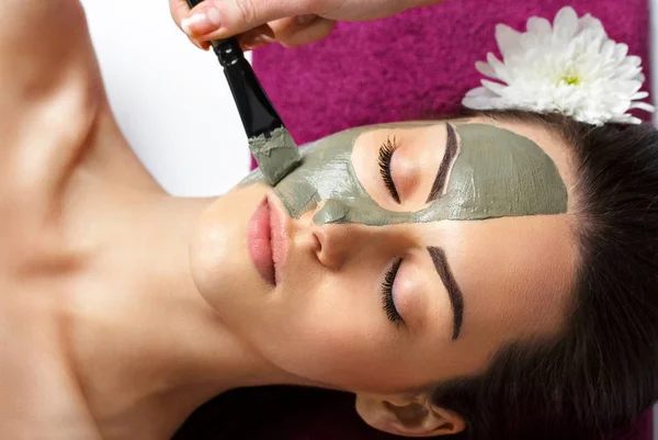 Kvinna med lera ansiktsmask i beauty spa. Hudvård. Skönhet Co — Stockfoto