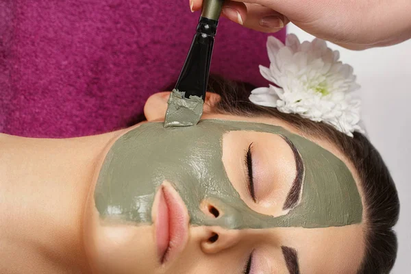 Conceito de spa. Jovem com máscara facial nutriente no salão de beleza, close-up — Fotografia de Stock