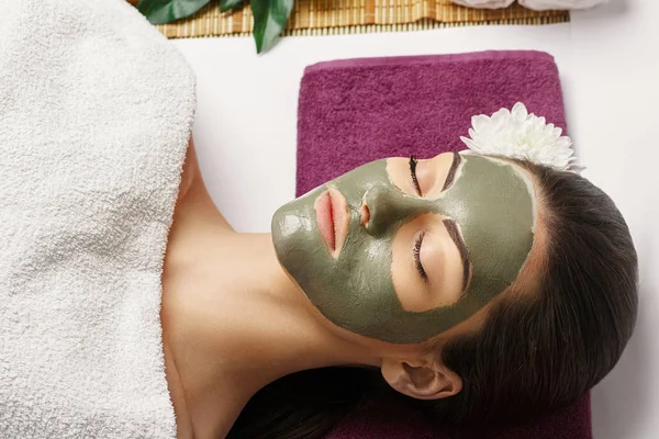 Spa Woman applying Facial clay Mask. Beauty Treatments. Close-up