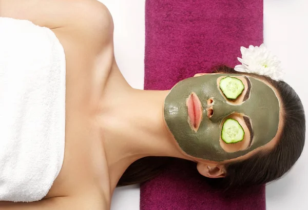 Spa Clay Mask. Woman with clay facial mask  and cucumbers on eye