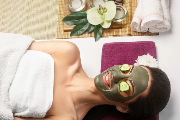 Spa Clay Mask. Wanita dengan masker wajah tanah liat dan mentimun di mata — Stok Foto