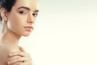 Güzellik ve Spa kavramı. Güzel genç kadın temiz taze cilt ile kendi yüz dokun. Yüz tedavi. Doğal Makeup.Cosmetology kız kadın var. Cilt Bakımı