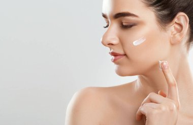 Güzel genç kadın temiz taze cilt ile kendi yüz dokun. Kozmetik, güzellik ve spa.