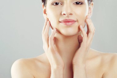 Güzellik ve Spa kavramı. Güzel genç kadın temiz taze cilt ile değmek kendi yüz ve Smiling.Facial tedavi. Kız erkek doğal Makeup.Cosmetology ile.