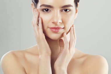 Güzellik ve Spa kavramı. Güzel genç kadın temiz taze cilt ile değmek kendi yüz ve Smiling.Facial tedavi. Kız erkek doğal Makeup.Cosmetology ile.