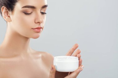 Güzellik kavramı. kadın bir nemlendirici elinde tutar ve onu cilt ve kırışıklık gelen kirleri nemlendirmek için yüzünde yayılır. vücut bakımı, Cilt Bakımı. Teni çok iyi