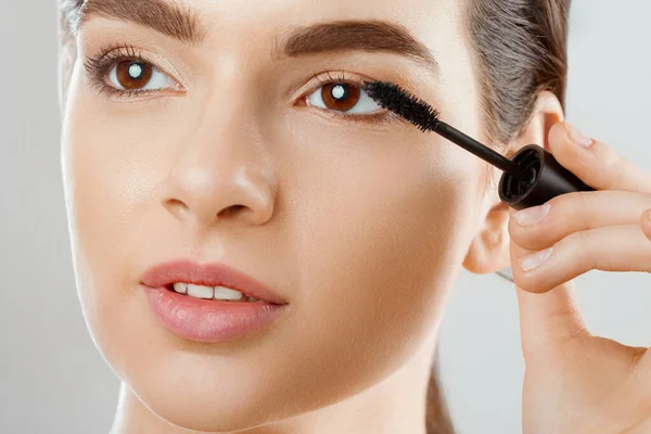 Mascara close-up van een mooie jonge vrouw een gezicht met een schoonheid — Stockfoto