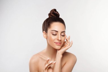 Güzel kadın portresi, cilt bakımı, cilt bakımı. Dermatoloji. Yüzüne dokunan manikür tırnaklı kadın elleri portresi. Spa mı? Kız kozmetik ürünleri. Yüz bakımı. Yumuşak cilt ve çıplak omuzlar, açık renk çıplak makyajlı bir model..